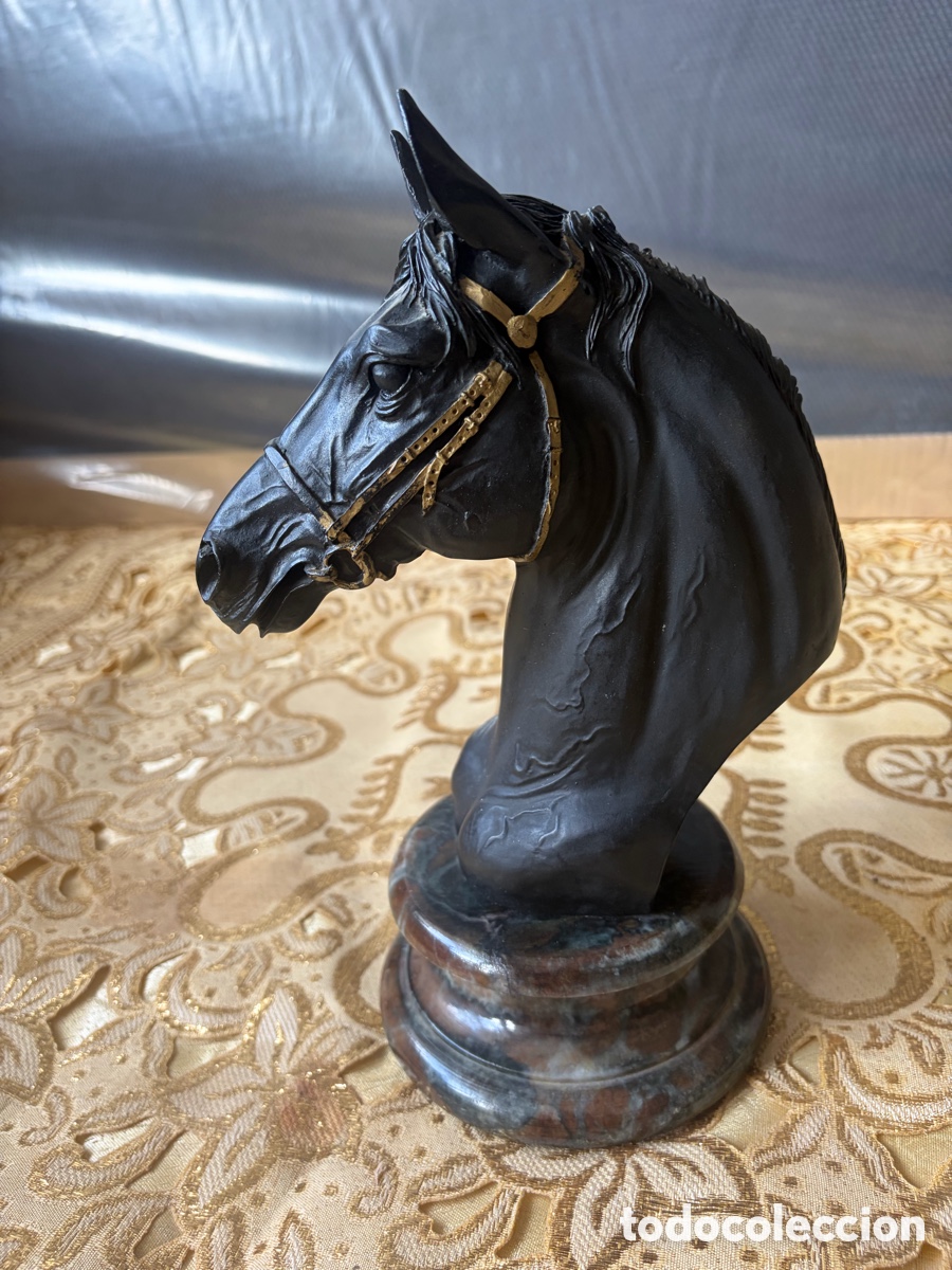 Arte: Busto de caballo negro con detalles en dorado y peana en dorado.
