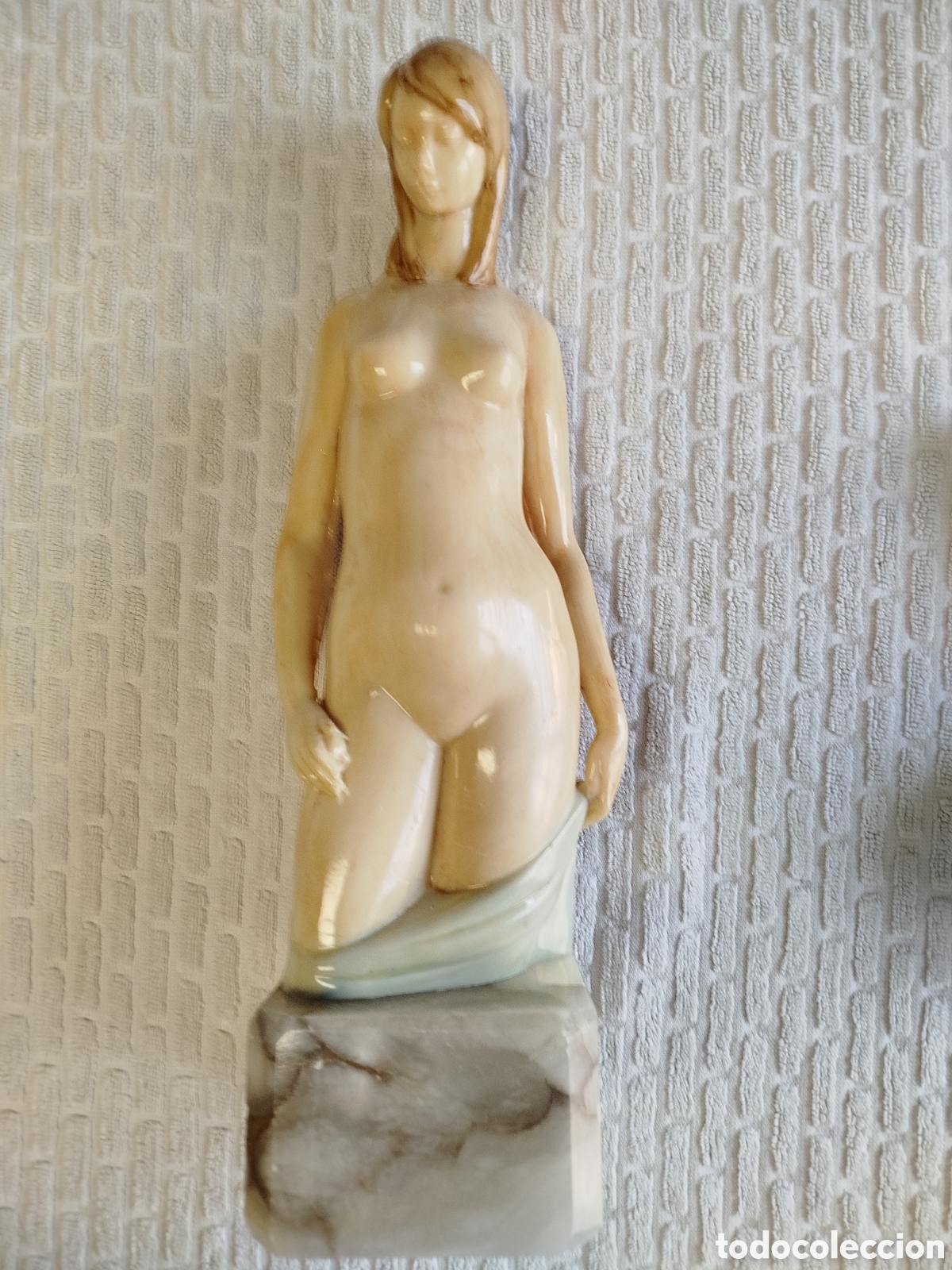 Art: Escultura de mujer desnuda, resina sobre peana m&aacute;rmol veteado. Autor desconocido.