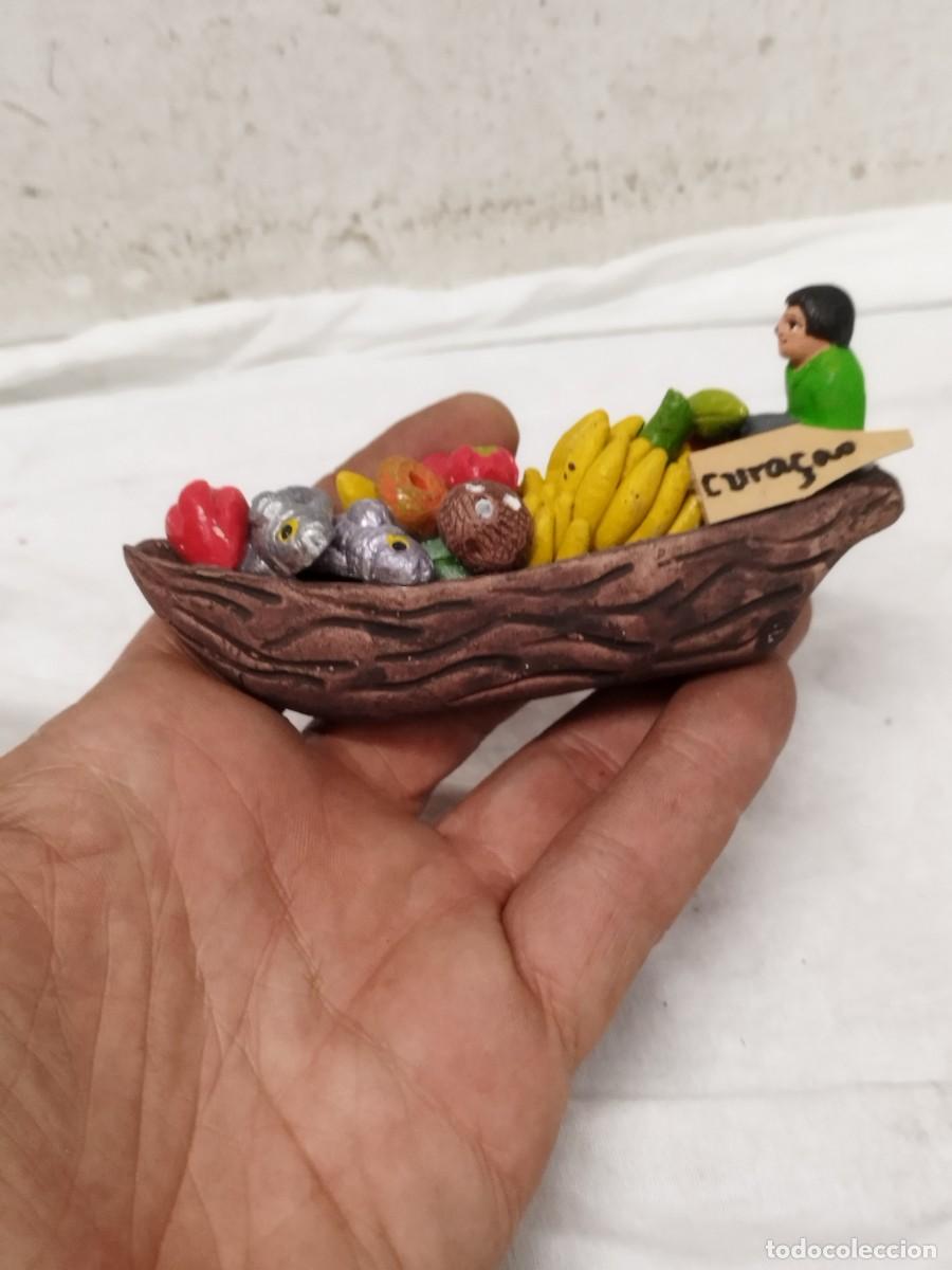 Arte: Figura miniatura de canoa con vendedor de frutas y pescados - Souvenir de Cura&ccedil;ao. Barro policromado