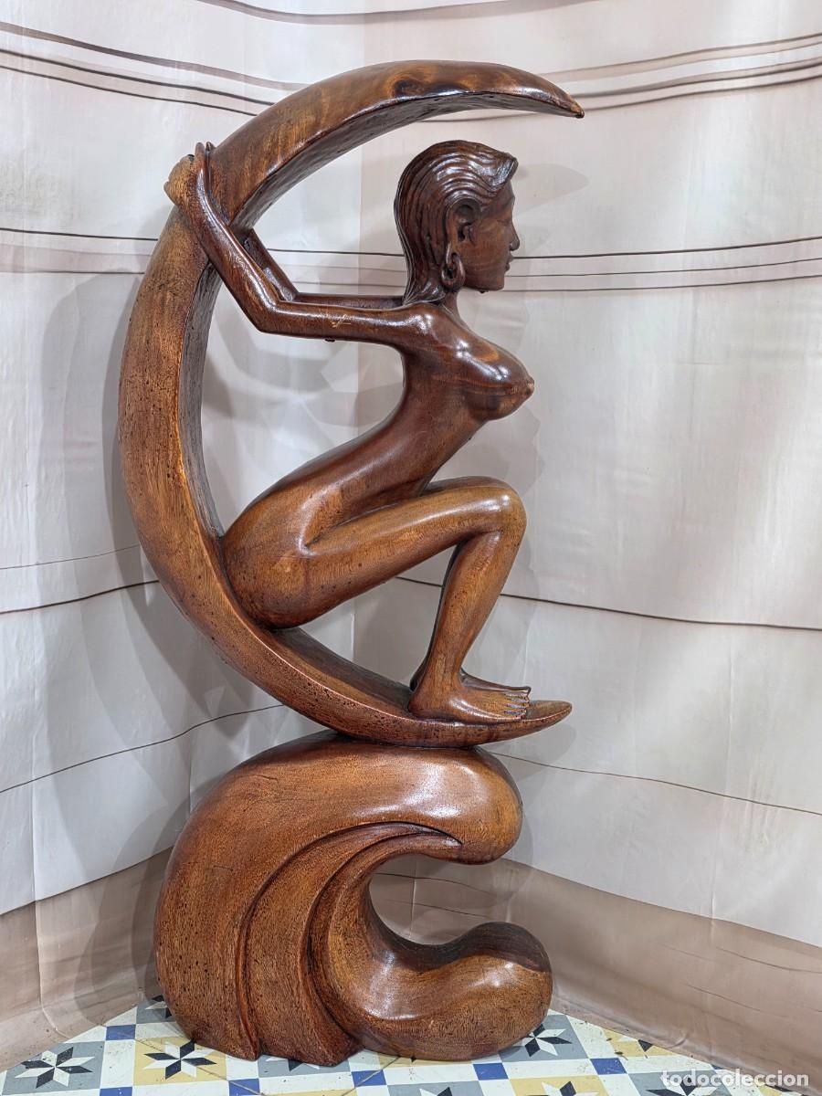 Arte: Escultura tallada a mano representa a una mujer sentada sobre una media luna