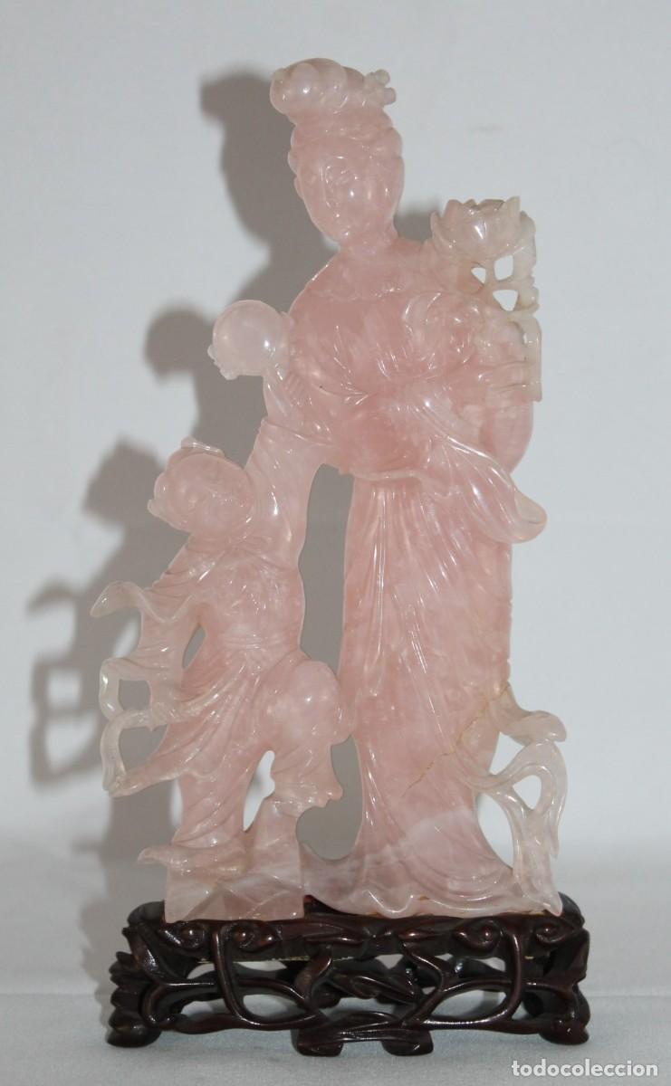 Arte: Escultura china de cuarzo rosa tallado. Figura femenina con ni&ntilde;o. Base de madera. Siglo XX