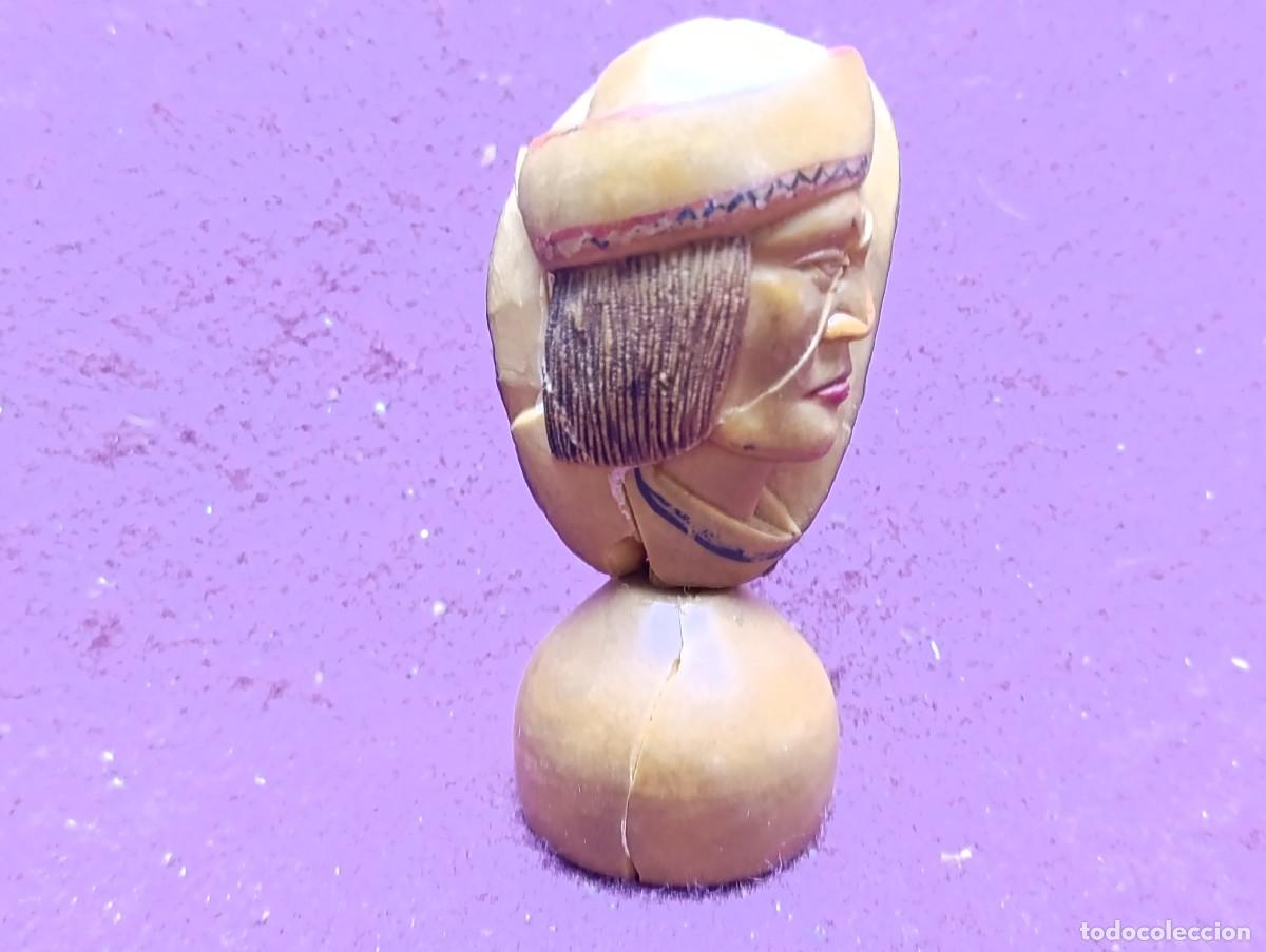 Arte: Figura de rostro de perfil ind&iacute;gena, tallada a mano en semilla del Amazonas