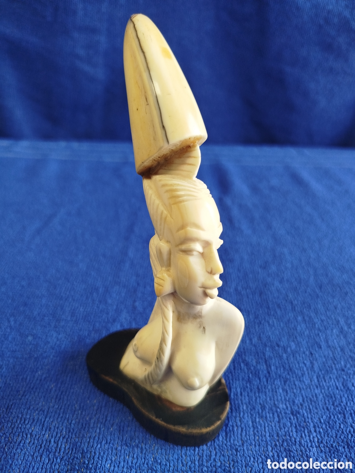 Arte: Escultura de mujer tallada en colmillo de fac&oacute;quero/jabal&iacute; africano sobre &eacute;bano.