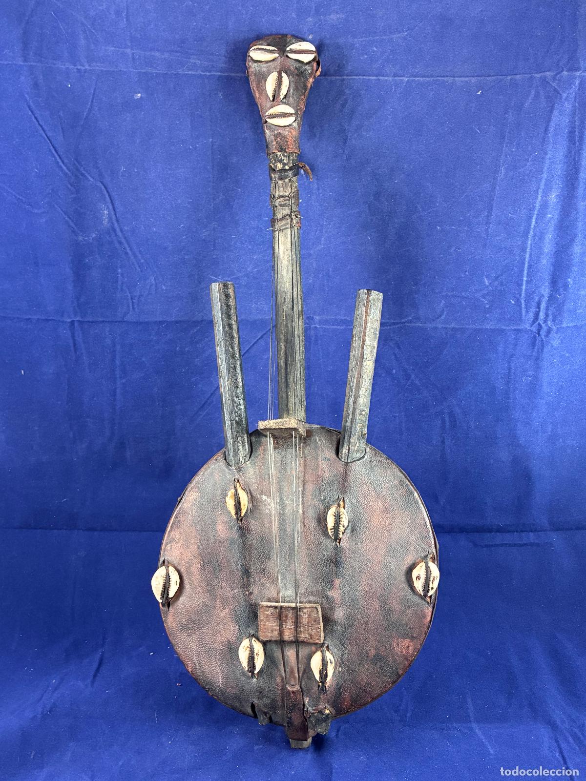Arte: Instrumento musical africano de cuerda tipo kora con caur&iacute;es y madera tallada. 50 cm, decorativo