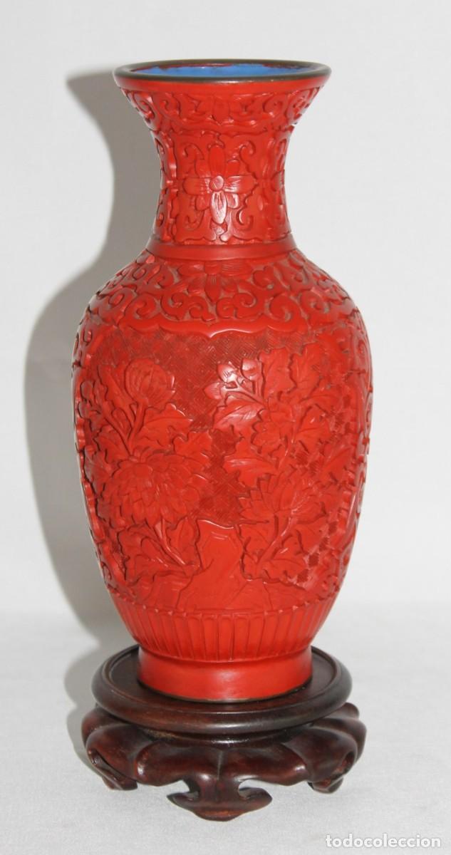 Arte: Jarr&oacute;n chino de laca roja de cinabrio tallada con flores. Interior esmaltado azul. Peana de madera