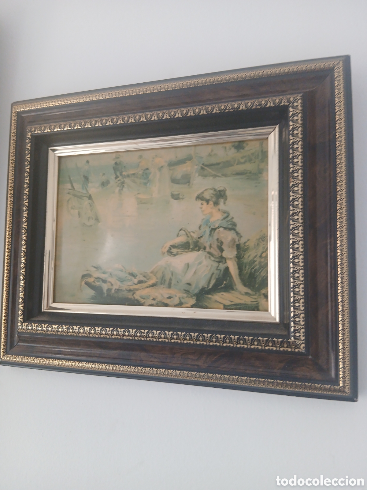 Arte: Antiguo cuadro enmarcado con escena costumbrista de una mujer junto al puerto. Sin firma visible. Se