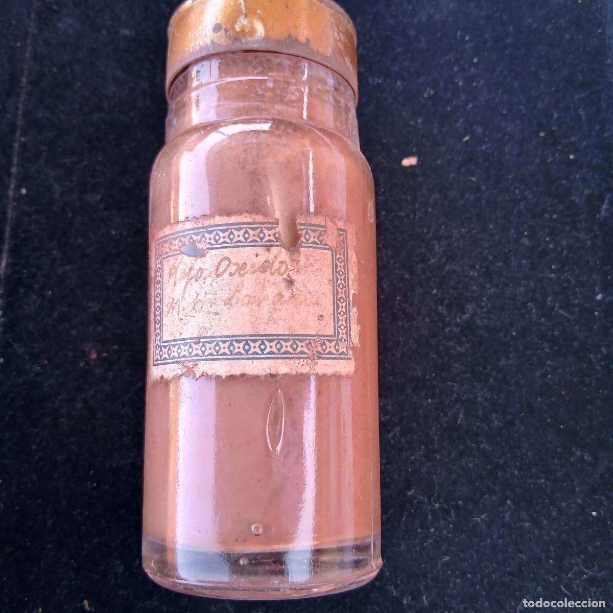Arte: Antiguo frasco de pigmento rojo oxido