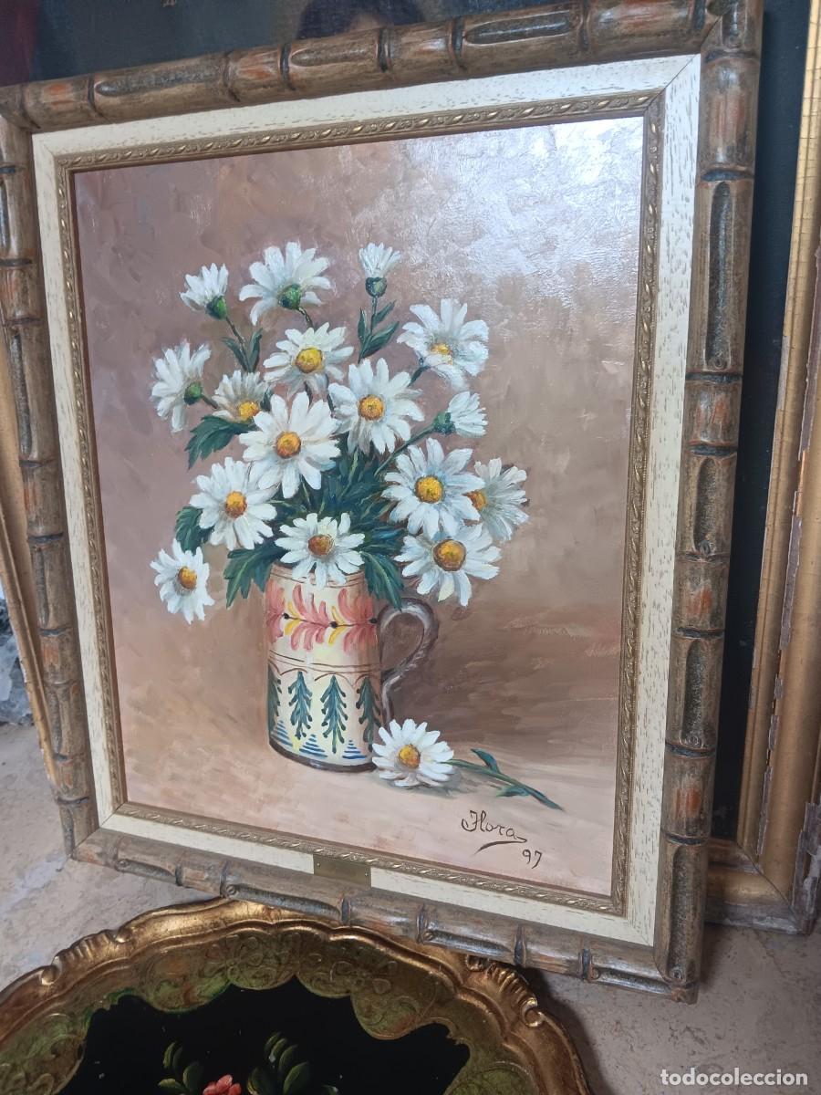 Arte: pintura al &oacute;leo de un bodeg&oacute;n de margaritas blancas en un jarr&oacute;n, firmada &rdquo;Flora&rdquo; y fechada en 1997.