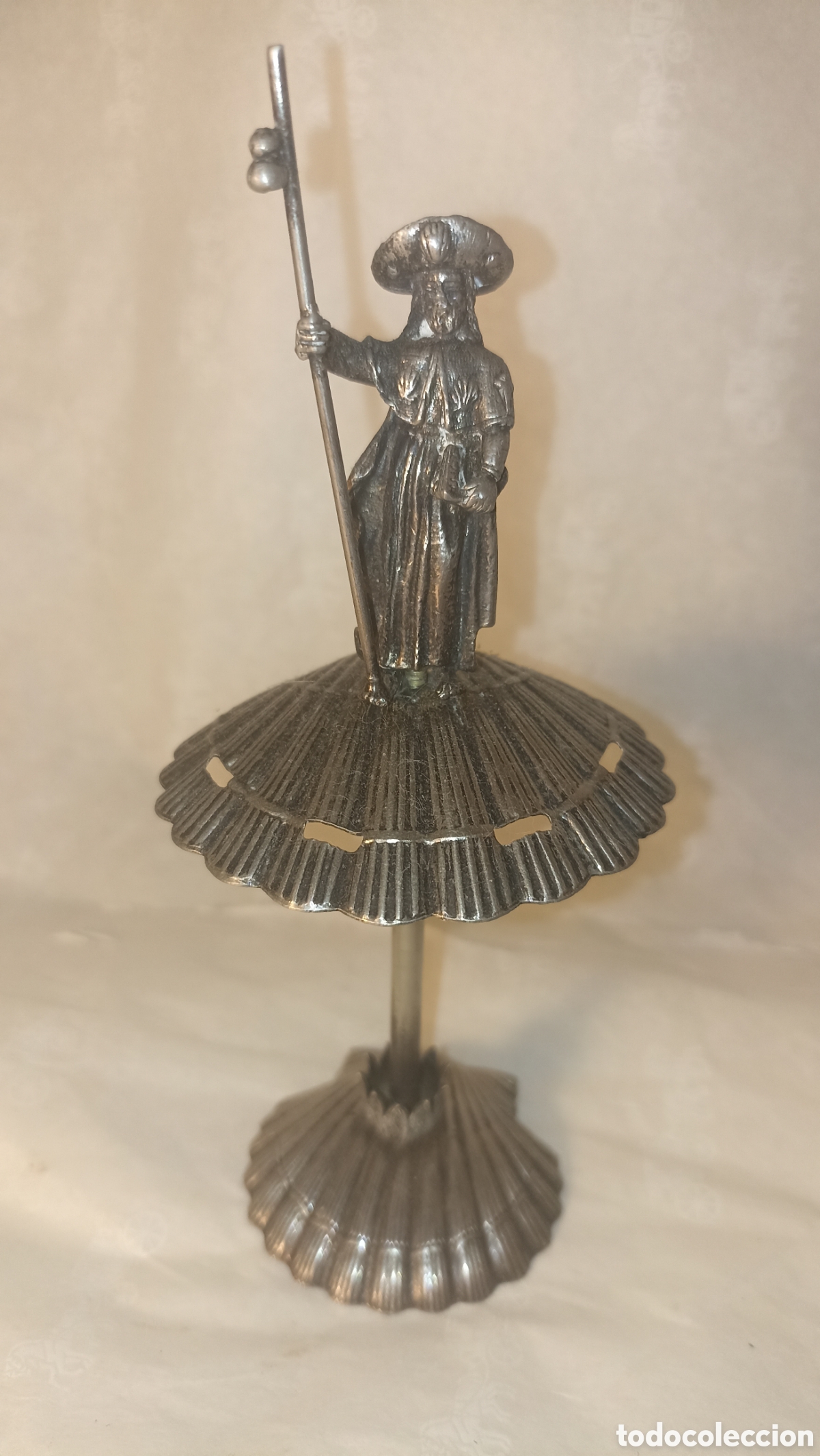 Arte: una figura de recuerdo met&aacute;lica del Ap&oacute;stol Santiago sobre una base de concha15 cm altura