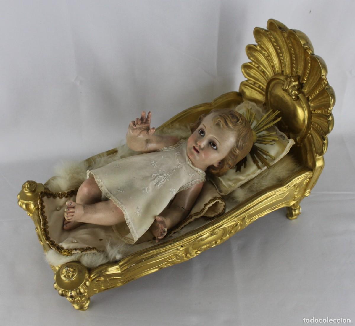 Arte: Ni&ntilde;o Jes&uacute;s de Olot en estuco con cuna de madera dorada. Ojos de cristal