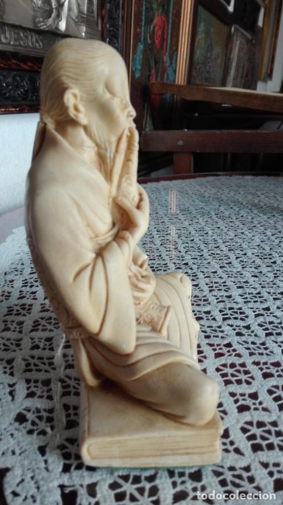 Arte: Monje sentado en un libro de marfilina tocando la flauta - Foto 2