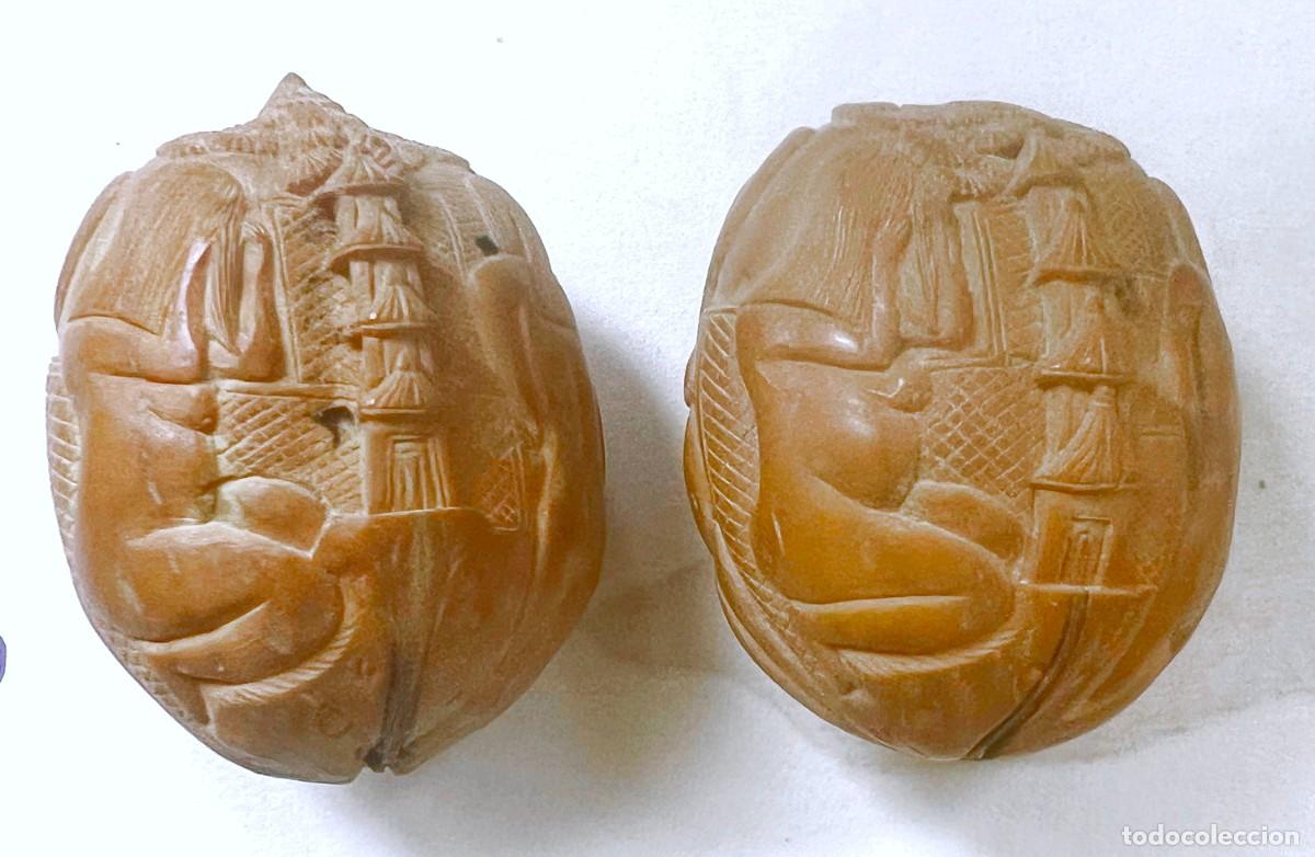 Kunst: Pareja de nueces talladas en relieve. Salamandra. Pagoda. Cuerpos femeninos desnudos. Flores. S. XX