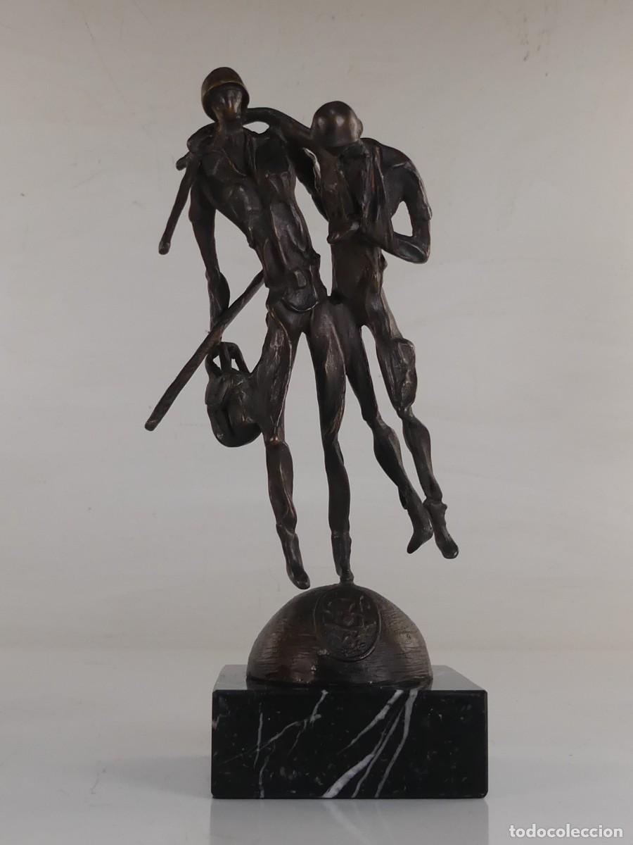 Kunst: Escultura de bronce sobre una base de m&aacute;rmol que representa a dos soldados, ayud&aacute;ndose