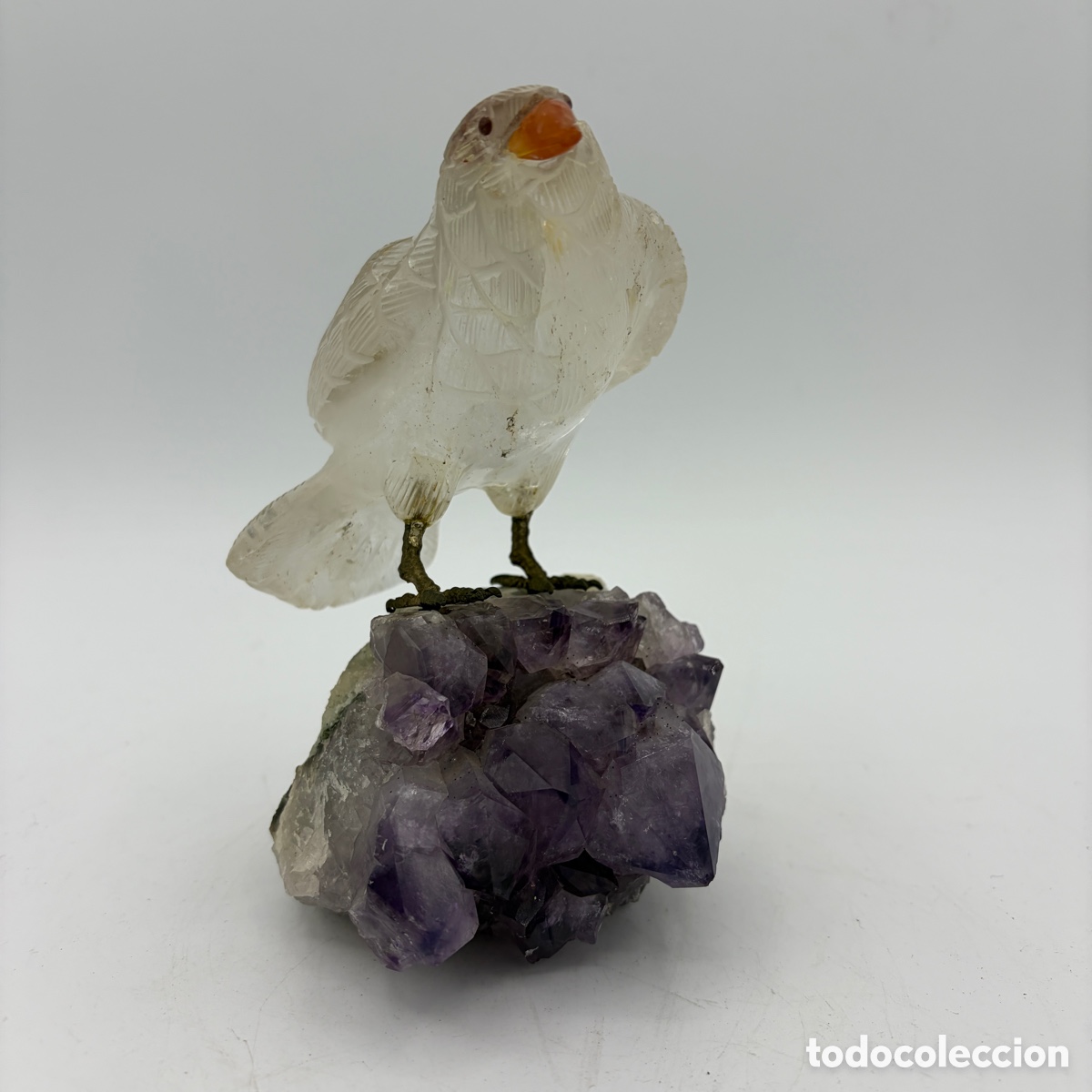 Arte: Figura de p&aacute;jaro tallado en cristal de roca sobre base de amatista, 15 cm.