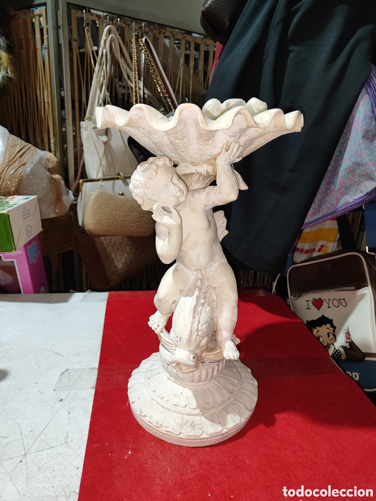 Arte: Peque&ntilde;a fuente bautismal estilo neocl&aacute;sico de yeso con querub&iacute;n sobre pescado y concha para agua
