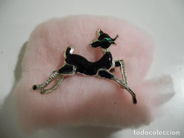 Schmuck: Broche en cromado y negro con detalle verde