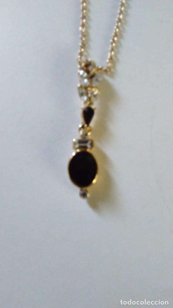 Joalharia: Cadena con colgante de metal dorado con piedras blancas y negras.