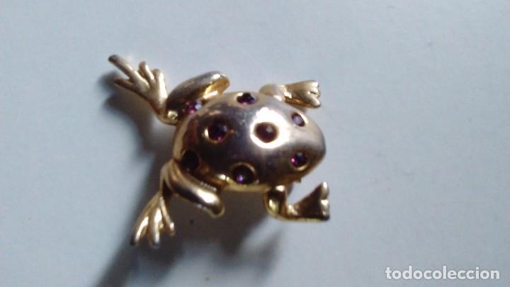 Joalharia: Broche de metal dorado con piedrecitas rojas en forma de rana