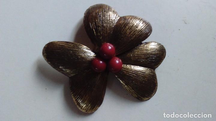 Schmuck: Broche de metal plateado en forma de tr&eacute;bol con adorno rojo en el centro