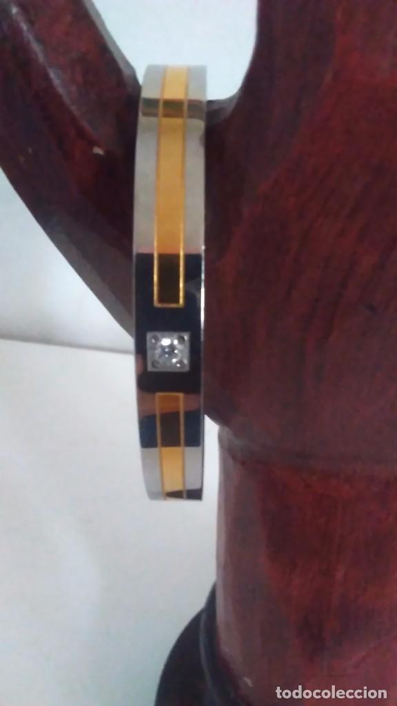 Joaillerie: Pulsera r&iacute;gida de dos metales con adorno de piedra transparente