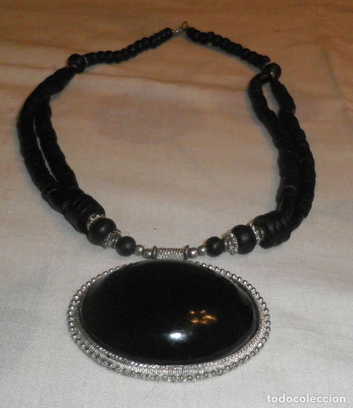 Joalharia: collar piedras negras y metal sujetando piedra de 7 cms en placa de metal