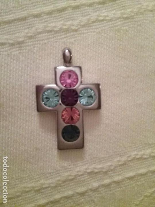 Joalharia: Cruz de metal con cristales de colores.