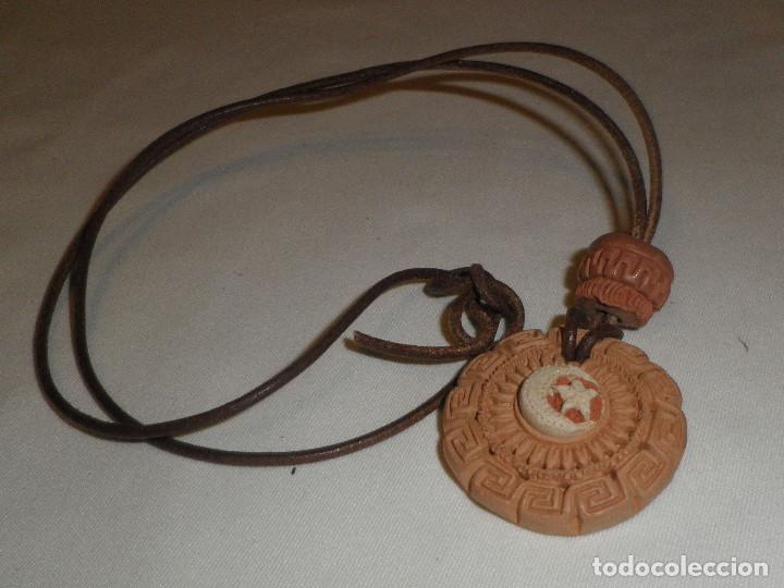 Joaillerie: colgante tunecino de terracota con la firma en la parte trasera