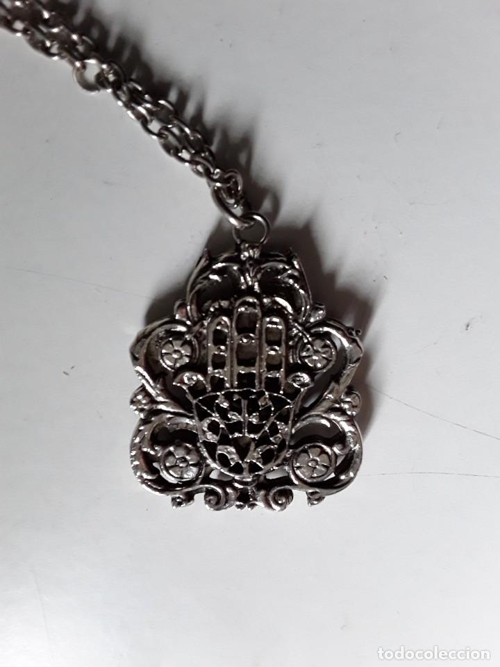 Joalharia: Colgante de metal plateado de la mano de F&aacute;tima y en la otra cara un camello