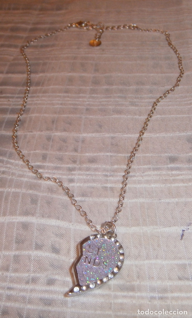 Joyeria: colgante medio corazon con piedrecitas brillantes y cadena plateada