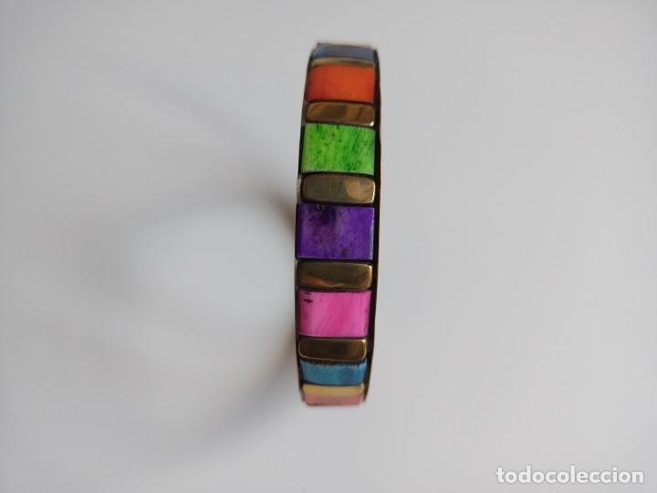 Gioielleria: Pulsera r&iacute;gida de metal con piedras o trocitos de hueso pintados de colores