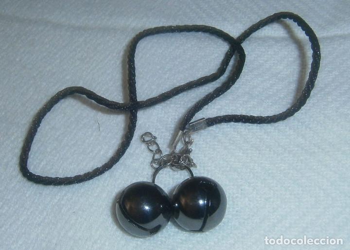 Joyeria: colgante cordon trenzado con dos cascabeles de metal grisacio