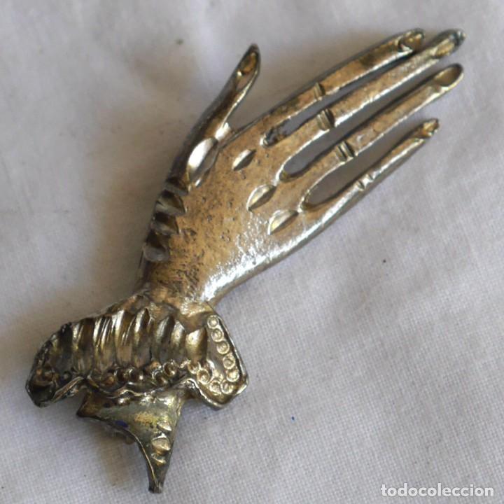 Gioielleria: Broche en metal plateado mano alargada