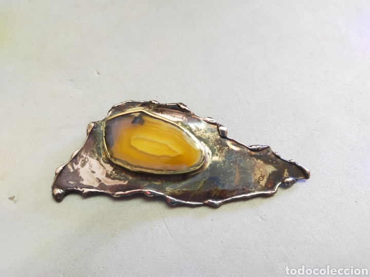 Joyeria: BROCHE DE ESTILO BRUTALISTA EN METAL Y PIEDRA CENTRAL.