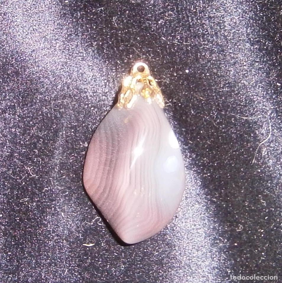 Joaillerie: colgante piedra morada y metal dorado