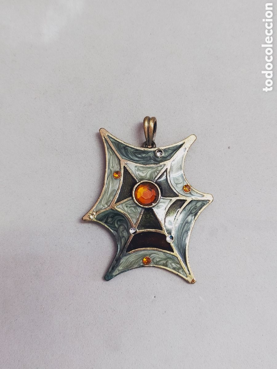 Joaillerie: COLGANTE DE METAL DORADO ESMALTADO CON FORMA DE TELA DE ARA&Ntilde;A.