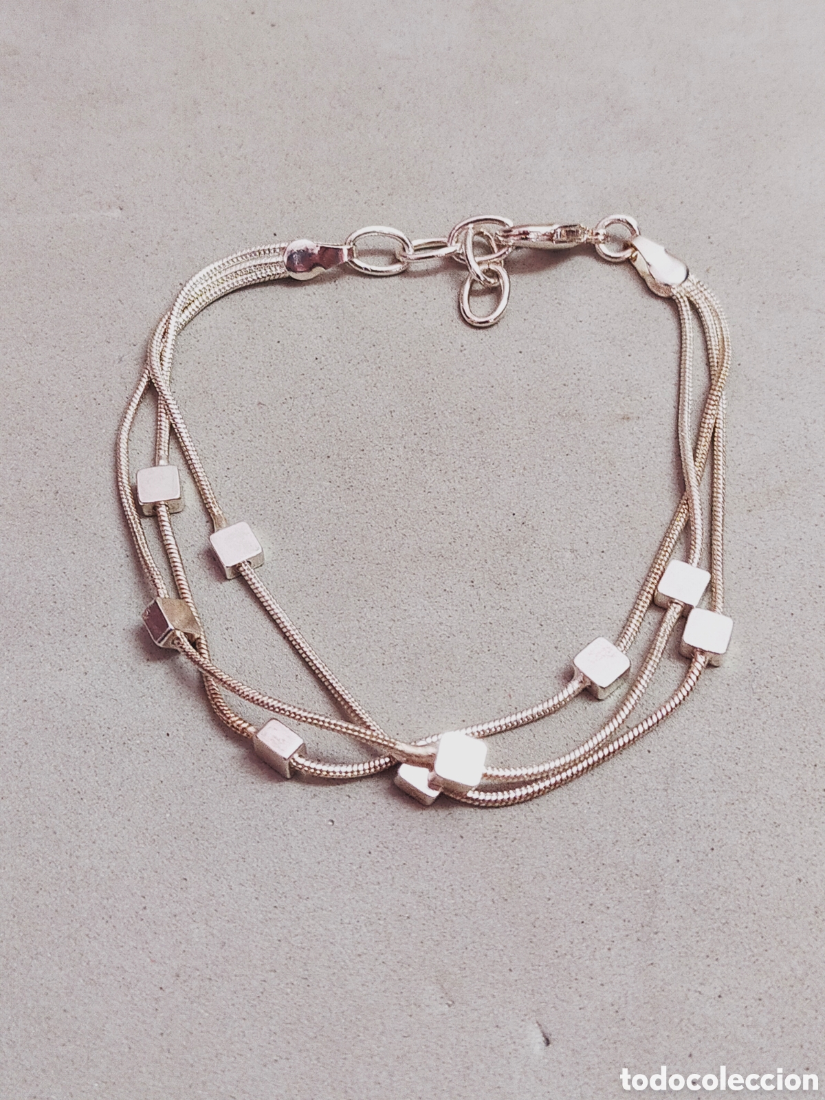 Joaillerie: PULSERA VARIOS CORDONES EN METAL PLATEADO. CON CUBOS DECORACION.