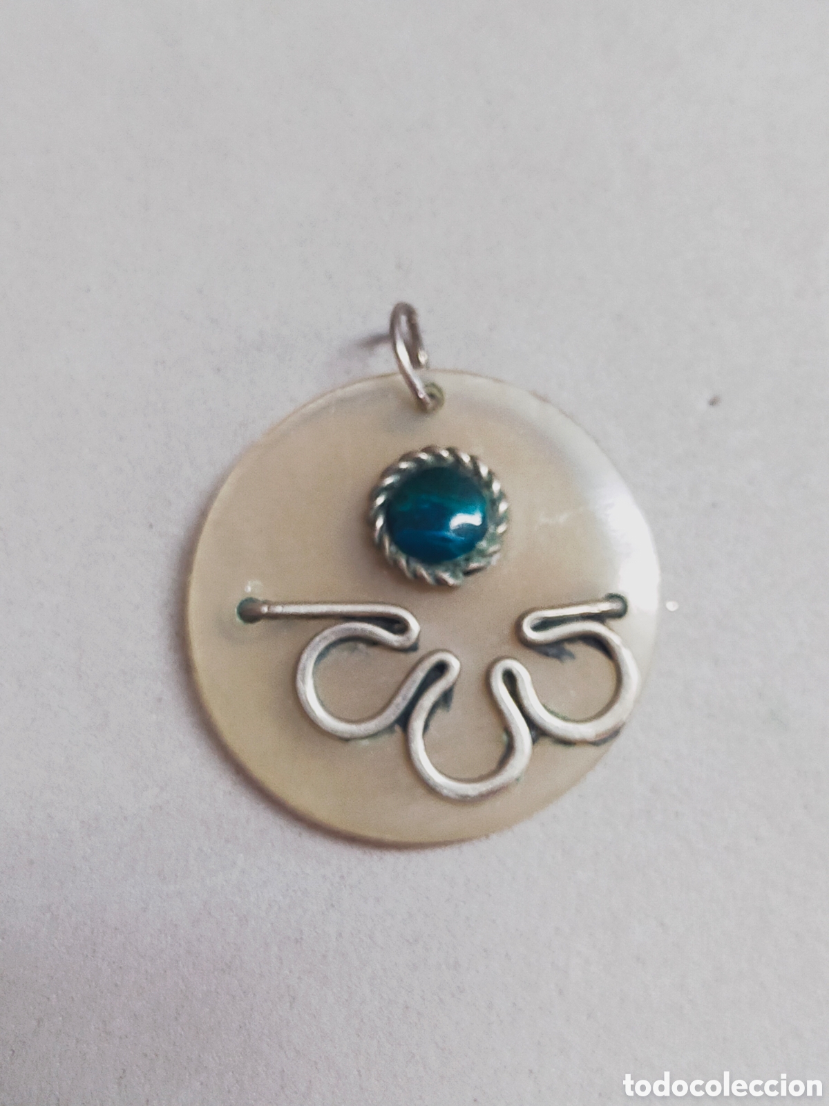 Joaillerie: COLGANTE EN RESINA CON DETALLES EN METAL Y PIEDRA AZUL.