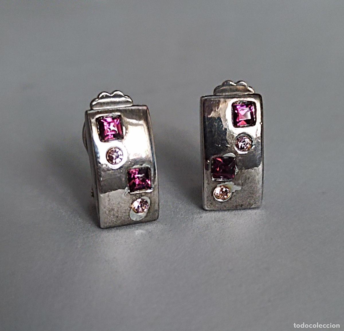 Joyeria: Pendientes plateados, con piedrecitas lilas, cierre de clip.