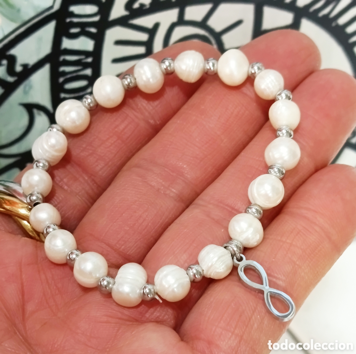 Joyeria: Pulsera de perlas naturales con infinito de acero preparada con palo santo, nueva
