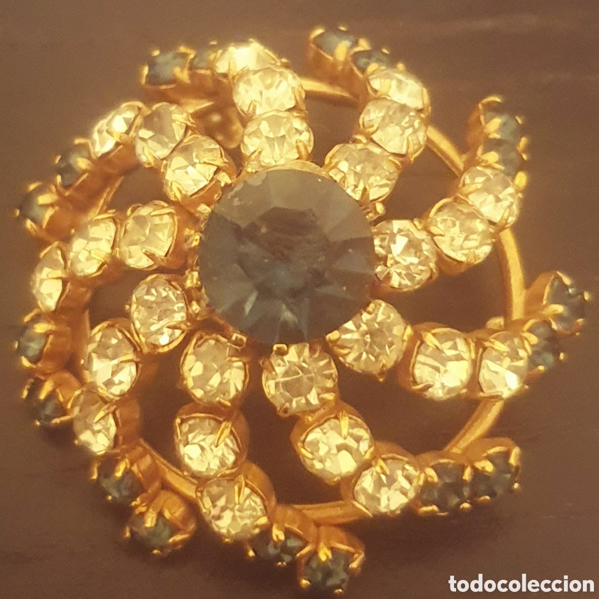 Joyeria: BROCHE EN METAL DORADO CON CRISTALES Y PIEDRAS AZULES.