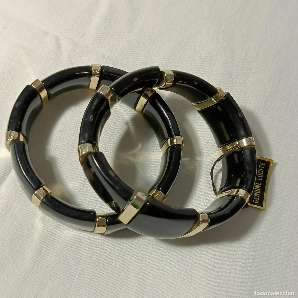 Gioielleria: Dos pulseras vintage, lucite, color negro y dorado.