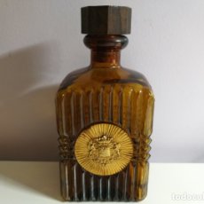 Botellas antiguas: BOTELLA DE VIDRIO. COLOR ÁMBAR. DECORADA CON ESCUDO DE METAL DORADO.. Lote 180879513