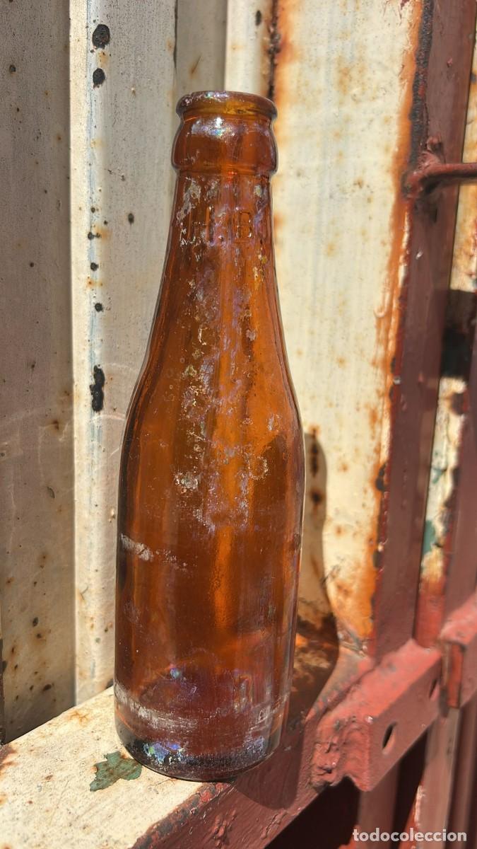 Botellas antiguas: BOTELLA ANTIGUA DE CERVEZA DE QUINTO DE RELIEVE EN LA BOCA H.B.