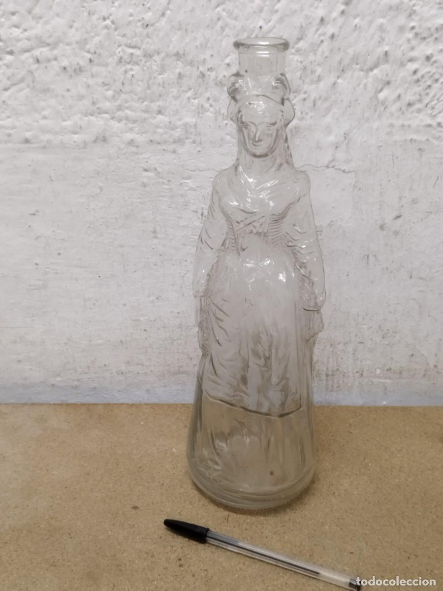 Botellas antiguas: Antigua, botella de cristal o vidrio transparente. Sin tap&oacute;n, forma mujer folcl&oacute;rica. Tradicional.