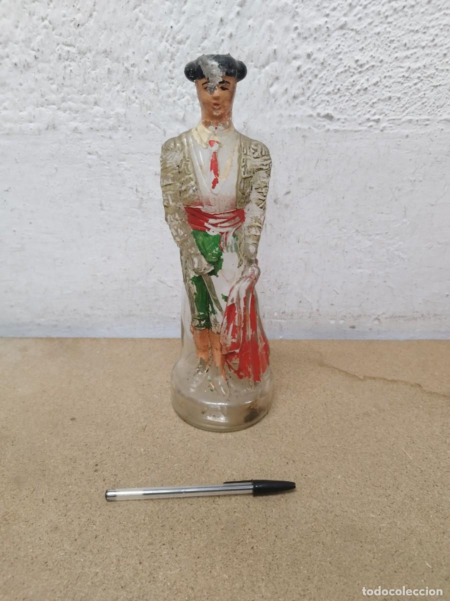 Botellas antiguas: Antigua botella de vidrio con forma de torero o matador, pintada a mano en relieve. Sin tap&oacute;n.