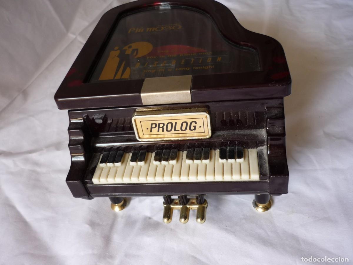Preciosa caja de música con forma de piano.Incluye banco y caja rígida