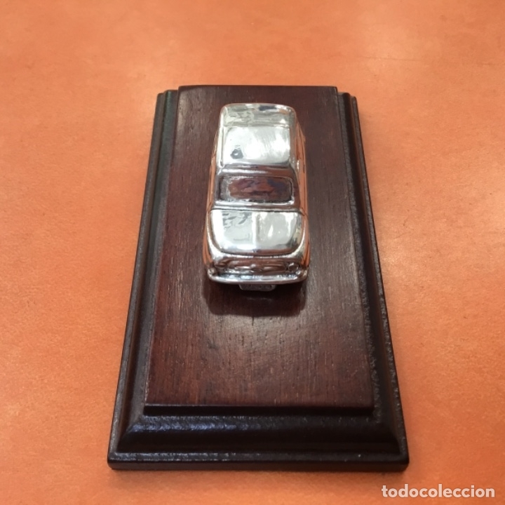 Coches a escala: Fiat 500 plateado sobre peana de madera