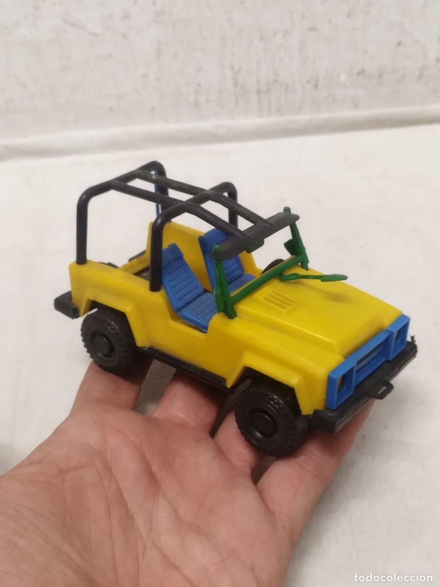 Coches a escala: Antiguo coche de juguete, jeep de color amarillo de explorador.
