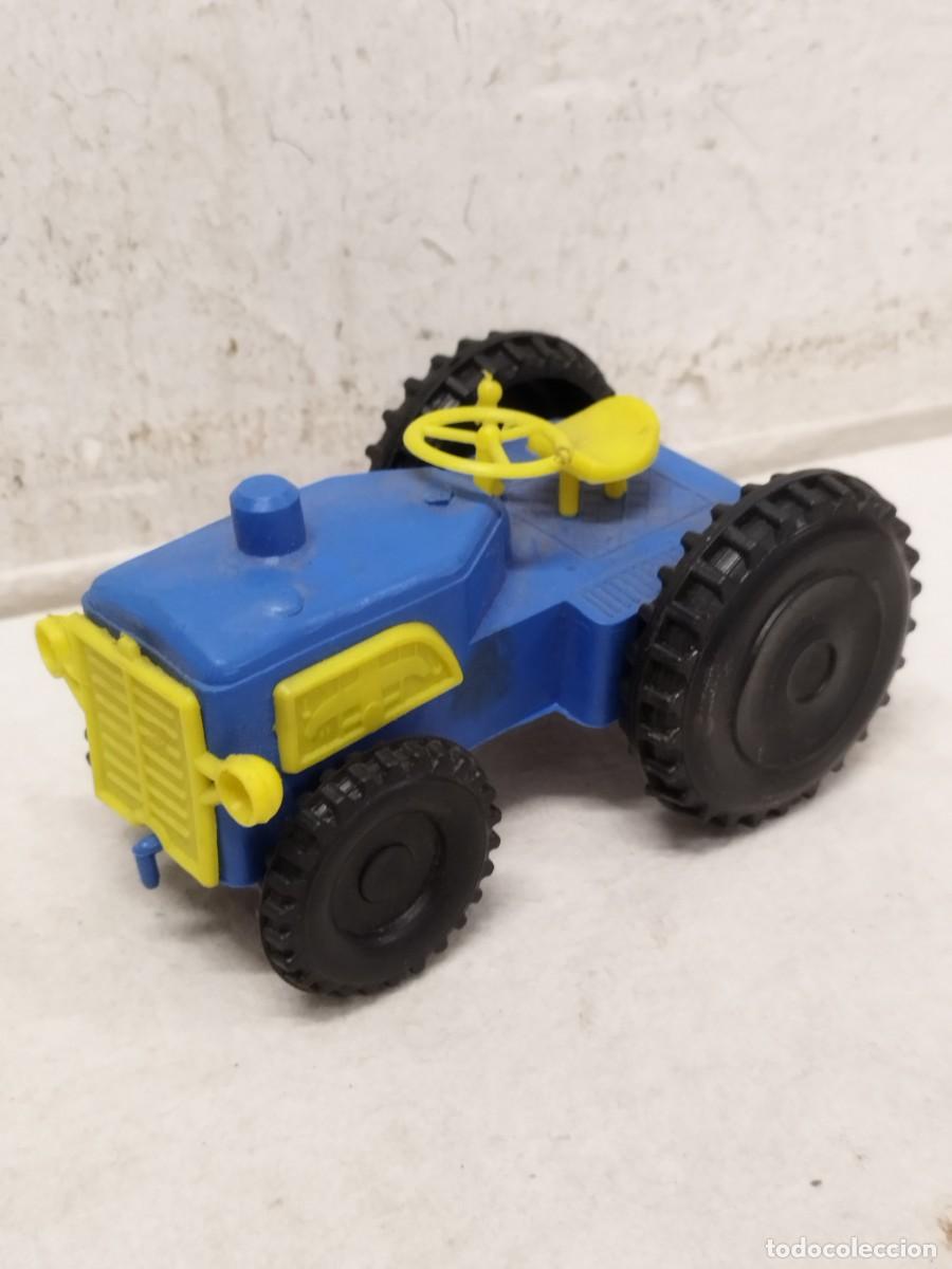 Coches a escala: Antiguo tracto de juguete de plastico de color azul y amarillo. Vehiculo agricola.