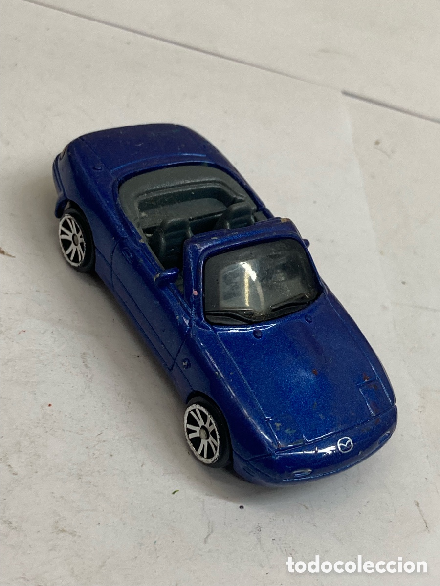 Coches a escala: Mazda MX-5 Miata azul, posiblemente fabricado por Hot Wheels o Motor Max